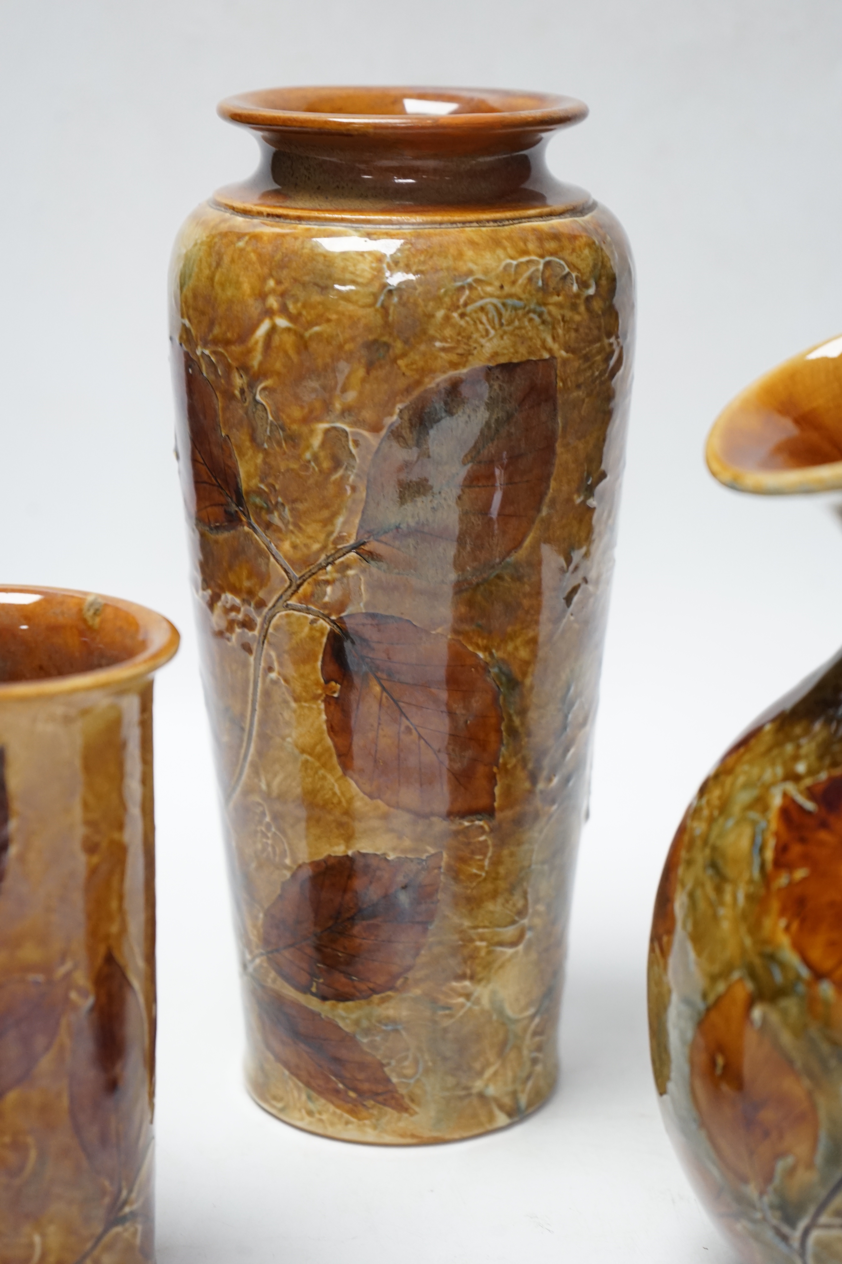 Two Doulton natural foliage ware vases and a jug, 25cm